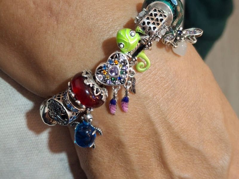 Pulsera armada con muranos, camaleón verde y atrapasueños, puesta en la muñeca
